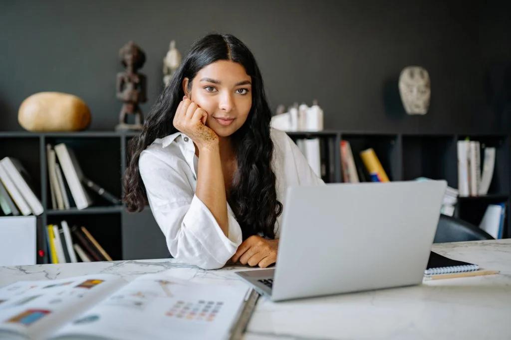 a woman sitting at a desk with a laptop