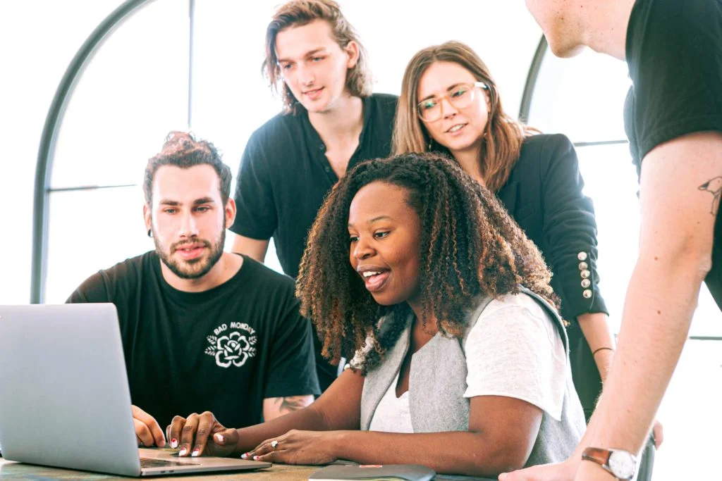 a group of people looking at a laptop